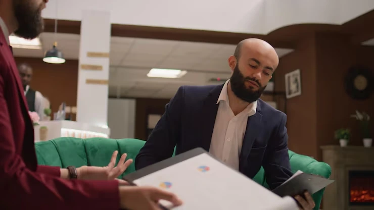 Two men discussing documents in office