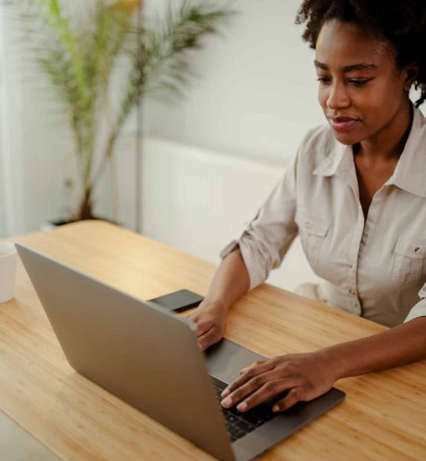 Concentrated afro american copywriter updating software on laptop computer in office, Intellectual Property Lawyer