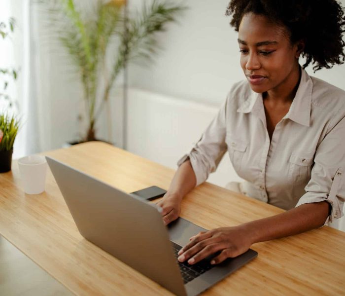 Concentrated afro american copywriter updating software on laptop computer in office, Intellectual Property Lawyer