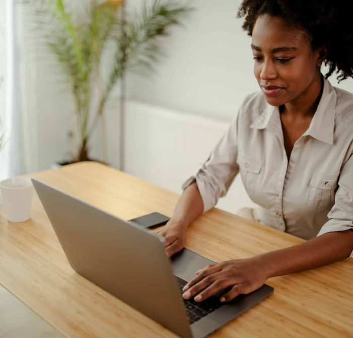 Concentrated afro american copywriter updating software on laptop computer in office, Intellectual Property Lawyer