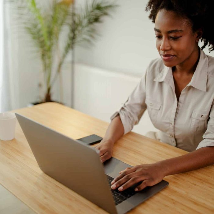 Concentrated afro american copywriter updating software on laptop computer in office, Intellectual Property Lawyer