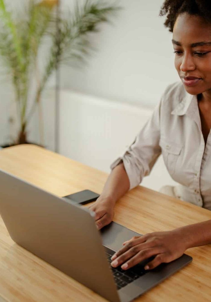 Concentrated afro american copywriter updating software on laptop computer in office, Intellectual Property Lawyer