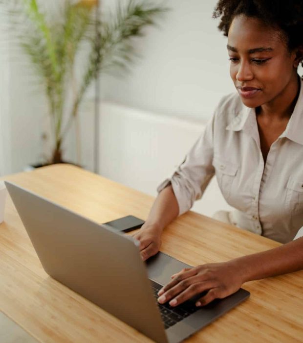 Concentrated afro american copywriter updating software on laptop computer in office, Intellectual Property Lawyer