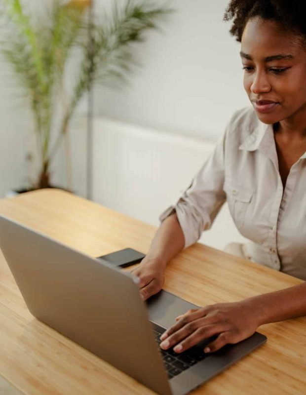 Concentrated afro american copywriter updating software on laptop computer in office, Intellectual Property Lawyer