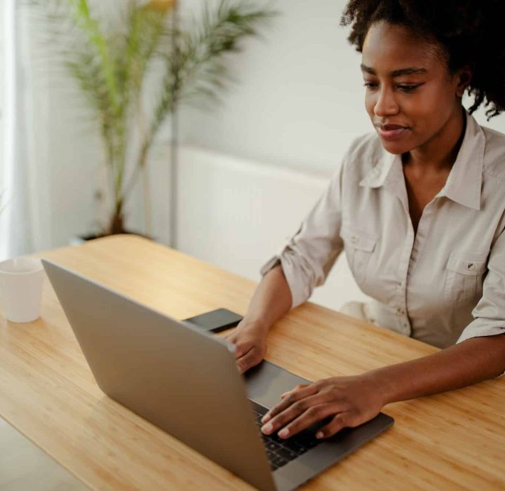 Concentrated afro american copywriter updating software on laptop computer in office, Intellectual Property Lawyer