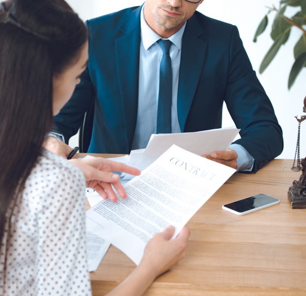 male lawyer looking at client reading contract
