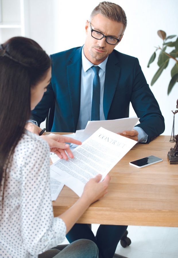 male lawyer looking at client reading contract