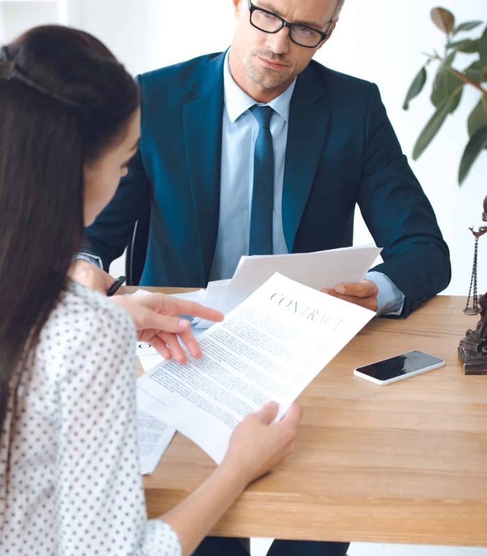 male lawyer looking at client reading contract, Judicial Review Lawyers