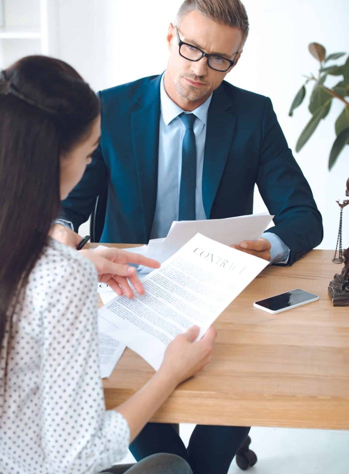 male lawyer looking at client reading contract, Judicial Review Lawyers