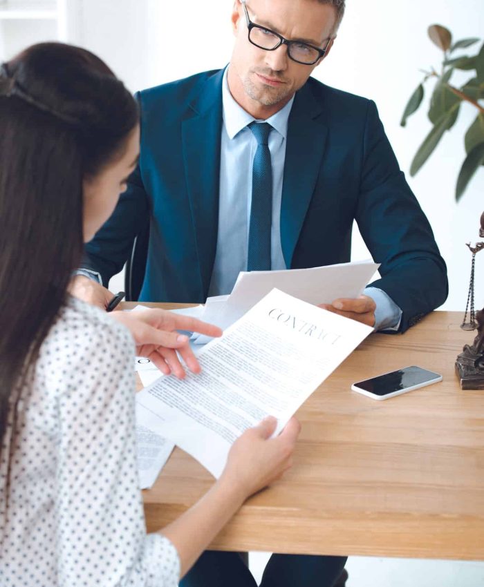 male lawyer looking at client reading contract, Judicial Review Lawyers