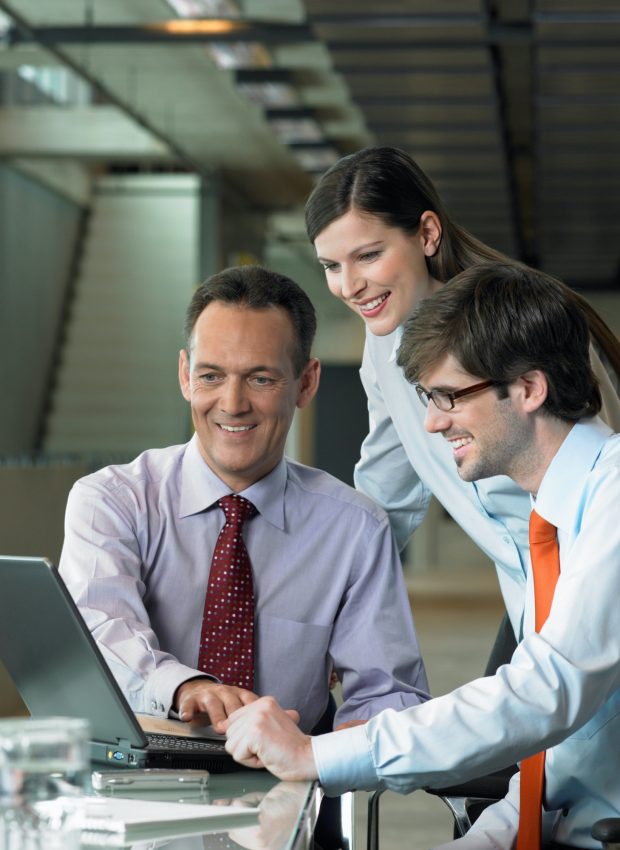 Three Businesspeople looking on laptop, Construction Contract Lawyer, Data Protection Lawyers, Media Lawyer, Surbiton Solicitors