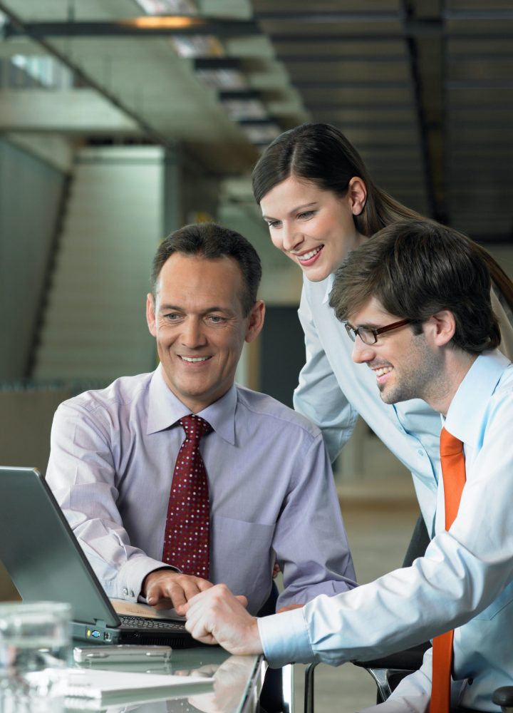 Three Businesspeople looking on laptop, Construction Contract Lawyer, Data Protection Lawyers, Media Lawyer, Surbiton Solicitors